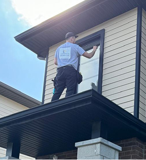 Laveurs nettoyant une vitre sur un toit a l'exterieur.